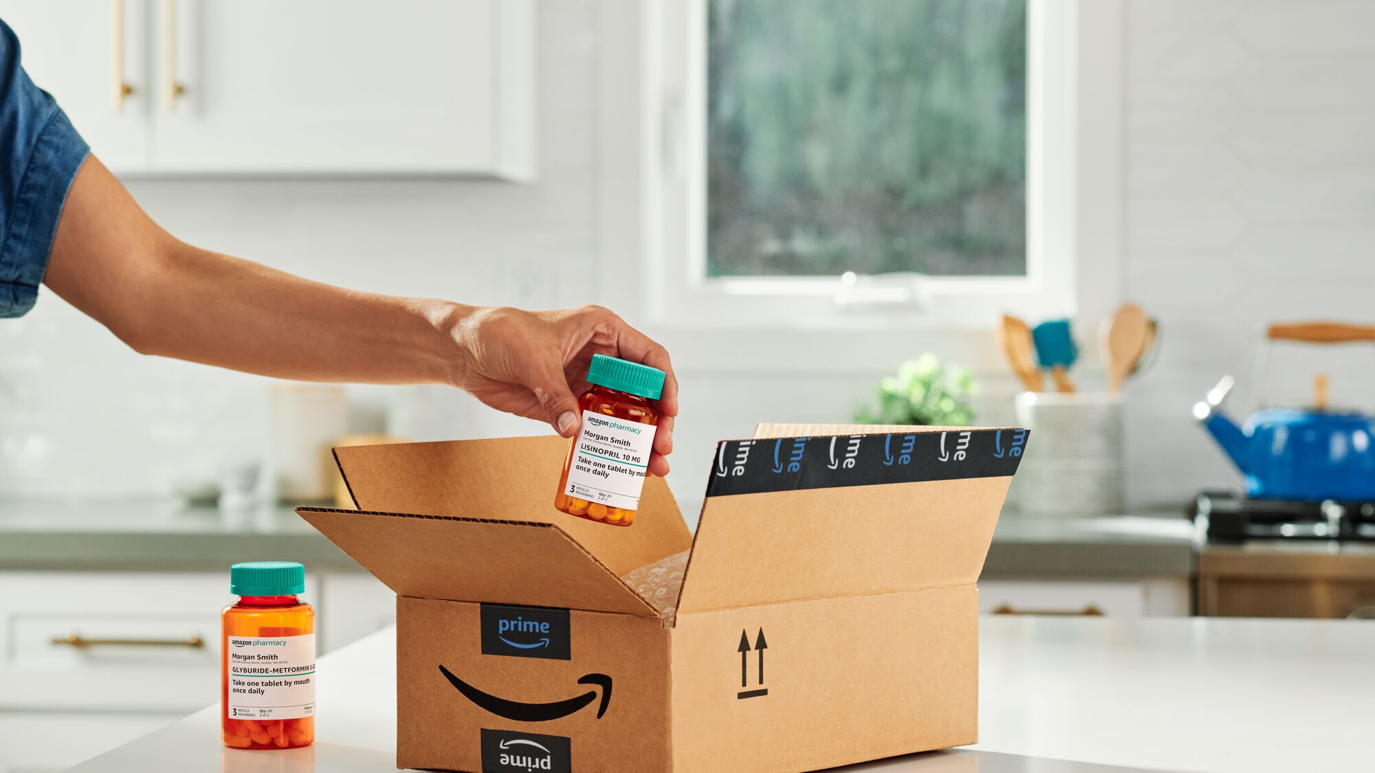 Hand placing prescription bottle into Amazon Prime delivery box